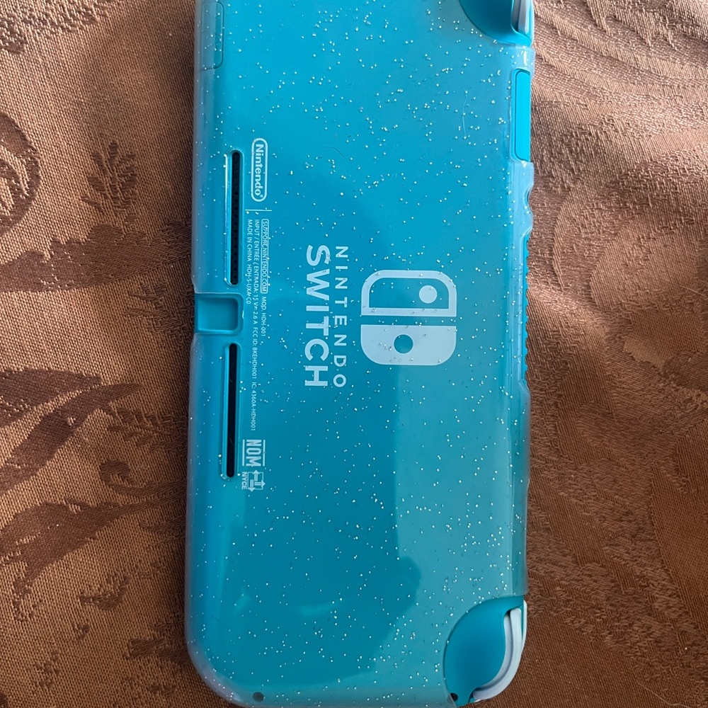 Nintendo Switch Lite in turquoise with charging cord and protective case